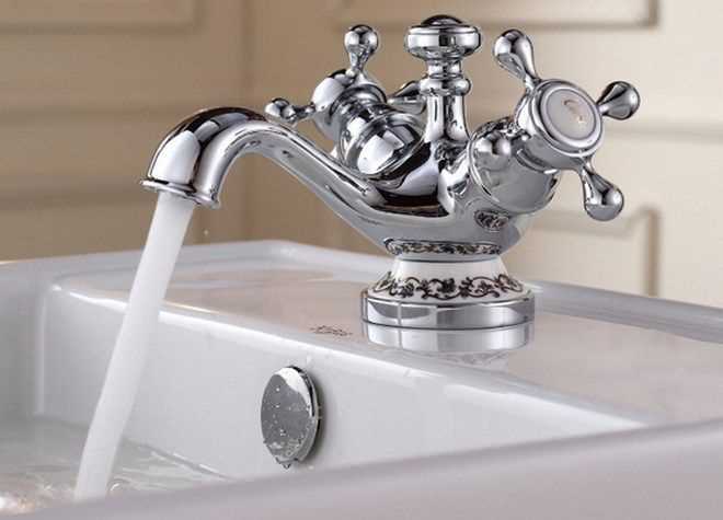 Перед началом необходимо undefinedперекрыть подачу воды</strong> и убедиться в ее отсутствии в трубопроводе. Старый смеситель демонтируется с помощью ключа, после чего очищаются посадочные поверхности и проверяется состояние <em>эксцентриков</em>. Изношенные детали подлежат замене. Расстояние между центрами входов у большинства моделей стандартное – 150 мм, что позволяет легко заменить старое устройство на новое без переноса труб.»></p>
<p>Уплотнение резьбовых соединений выполняется фум-лентой или сантехнической нитью, витки которой накладываются по ходу резьбы, не допуская перекрытия каналов. Смеситель монтируется вручную, с последующей легкой подтяжкой ключом. <strong>Избыточное усилие</strong> недопустимо – оно может привести к трещинам в корпусе. После установки выполняется проверка герметичности всех соединений под давлением.</p>
<p>При установке настенного смесителя особое внимание следует уделить <em>выравниванию эксцентриков</em> по уровню – это обеспечит правильную посадку корпуса без перекоса. Использование прокладок между смесителем и эксцентриками обязательно: они предотвращают протечки и компенсируют незначительные неровности поверхности. В случае возникновения течи необходимо повторно разобрать соединение и устранить причину – чаще всего это перекос прокладки или недостаточная герметизация резьбы.</p>
<h2>Выбор подходящего типа смесителя и его комплектующих</h2>
<p><img decoding=